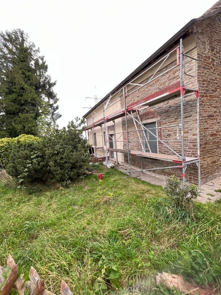 Schalungsarbeiten und Bewehrung für ein Betonfundament an einem Wohnhaus