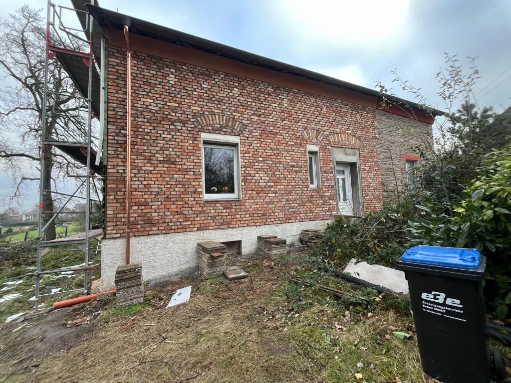 Einbau eines Mastfundaments in einer ausgehobenen Grube mit Holzverstrebung